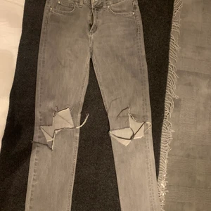 Gråa acne jeans med hål - Jag säljer dessa gråa jeans från Acne med hål på knäna. De är i storlek 26/32 och är perfekt längd för mig som är 169. Anledningen till varför jag säljer dem är för att de har börjat bli lite för små på mig. 