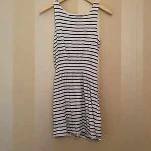 Randig klänning - Vit klänning med svarta ränder från hm. Resår i midjan.