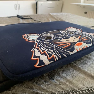 Kenzo datorfodral - Säljer ett Kenzo datorfodral som är köpt för några år sedan på raglady💓 det är i bra skick förutom några mindre smutsfläckar på baksidan! Jag får plats med en vanlig Mac book i den:)