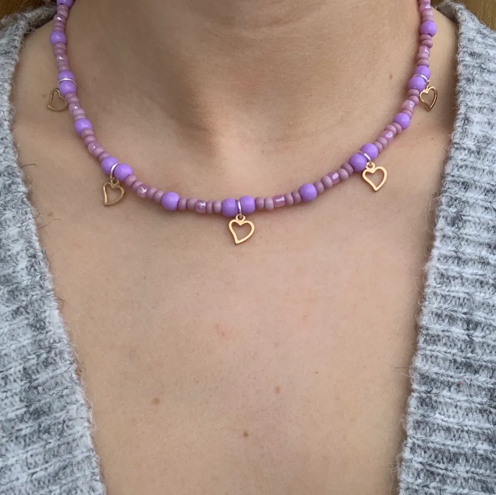 Lila pärlhalsband med små söta guldhjärtan 💜🥳⭐️🥺 halsbandet försluts med lås och tråden är elastisk . Accessoarer.