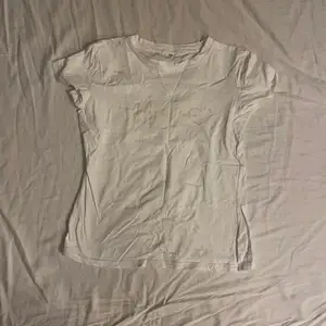 En vit t-shirt med beiget tryck från shein. Man kan välja spårar frakt men då blir frakten dyrare