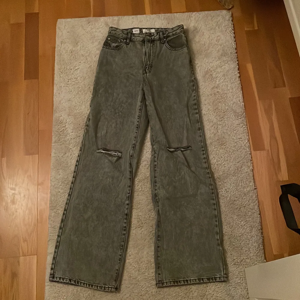 Jag säljer ett par snygga gråa jeans från Bershka, i deras 90’s modell. Modellen är wide leg med hål på knäna. De sitter snyggt, o passar mig som är 170 lång. Jag säljer de för 200kr. Kontakta mig vid intresse så kan vi diskutera priset. . Jeans & Byxor.