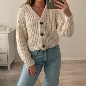 Vit stickad tröja  - Stickad tröja med bruna knappar, i creme vitt