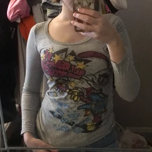 Tröja med tryck - Väldigt fin grå Långärmad tröja med tryck från japanska märket glad news. Två små hål på ena sidan nedredelen av tröjan där bak. (Syns på tredje bild)