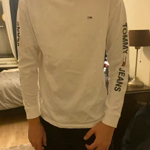 Tommy jeans tröja - Vit tröja med tryck av logga på brös och armar från tommy jeans. Storlek M, jag är 186.
