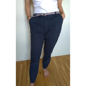 Mörkblåa byxor  - Använda, men i mycket bra skick. På byxorna står det strl 36, men jag uppskattar storleken till 38/40. På sista bilden syns det hur dem ligger på mig som annars är 36. Skärpet kommer med byxorna. Färgen är som på första bilden.