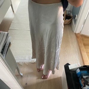 Satinkjol - Säljer denna långa satinkjol från Zara. Skulle säga att den är champagnefärgad. Storlek XS men eftersom den är stretchig i midjan passar den även större storlekar. Superfin men kommer inte till användning. Köpt för 400kr men säljer för endast 150kr. Använd fåtal gånger❤️
