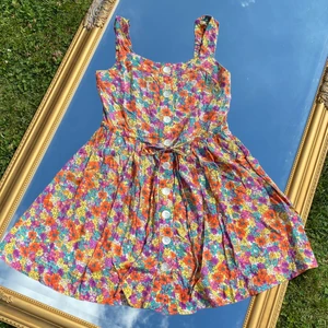 Kort blommig klänning - Kort, blommig klänning från indiska! Storlek XS. Den är  rätt så kort, men upplagd så det går att sprätta upp om man vill så blir den 5cm längre. Få paketpris vid köp av flera plagg! 🤩