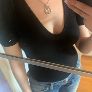 Bodysuit  - U-ringad svart body som knäpper mellan benen.