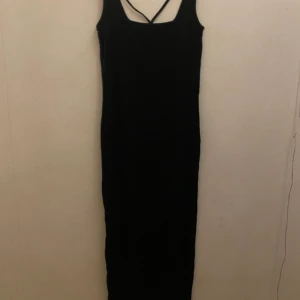 Tajt långklänning  - Lång klänning med detalj vid bysten 