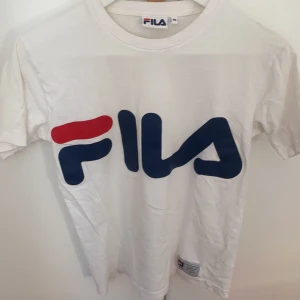 Vit Fila t-shirt  - En vit t-shirt med märket Fila. Säljs eftersom den inte kommer till användning