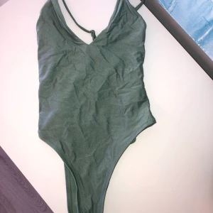 Baddräkt från bik bok swimwear🥰 - Säljer min grönglittriga baddräkt från bik bok swimwear då den tyvärr inte passar. Aldrig andvänt. Den är i storlek XS men har inställbara band! Jag brukar vara en XS men den här är för stor för mig då jag är väldigt kort. Säljer den för 100kr! Skriv till mig vid intresse eller om du vill ha fler bilder.