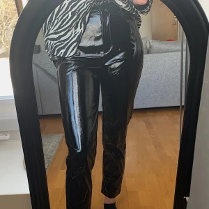 Lackbyxor  - Oanvända lackbyxor från NAKD. Jättefin passform och längd, perfekta till ett par klackar i vår!💃 Säljer då dem tyvärr inte kommer till användning🖤