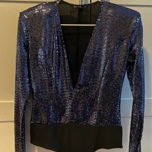 Paljettbody - Mörkblå paljettbody med djup urringning ifrån Nelly, storlek M. Helt oanvänd. Frakten står jag för🌸
