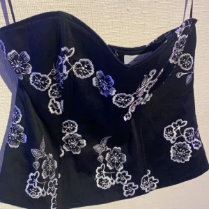 Svart korsett med vita detaljer - Svart korsett med vita detaljer, aldrig använd :).   Strl: L (42/44)