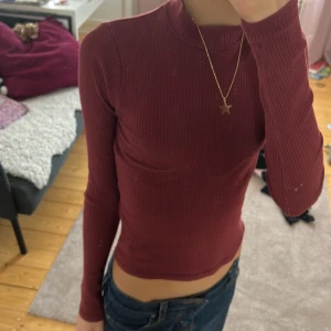 Vinröd ribbad tröja från Hollister - Säljer en vinröd ribbad tröja från Hollister. Tröjan har en slim passform och långa ärmar, perfekt för en stilren look. Den är tillverkad i ett mjukt material som känns skönt mot huden❤️Den är i mycket bra skick och knappt använd!!!!