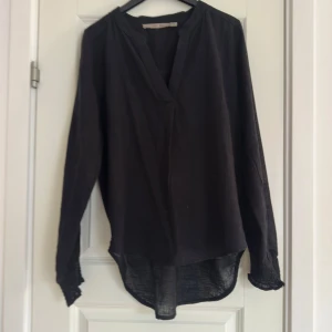 Svart lätt blus från Costa Mani - Lätt blus med räfflad mudd, perfekt att klä upp men även på en simpel vardag!💕kontakta för mer information.
