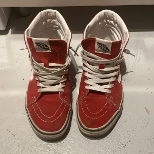 Röda sneakers från Vans - Säljer ett par klassiska röda Vans sneakers med vit snörning och vit sula. Skorna har en högre modell med vadderad krage för extra komfort. Nypris 1200kr