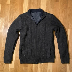 Stickad fodrad cardigan - Säljer en stickad kofta med dragkedja och ribbade muddar. Insidan är fodrad med mjukt material för extra värme. Perfekt för kyliga dagar. Två fickor framtill ger extra funktionalitet. Ifall mer frågor skriv gärna!