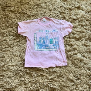 Rosa t-Shirley - Säljer en rosa t-shirt med tryck. 