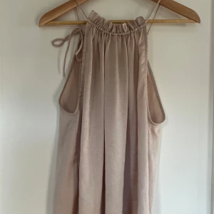 Beige topp  - Säljer en beige topp från Neo Noir. Den är ärmlös med knytband vid axlarna och har en luftig passform. 