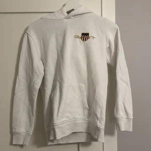 Vit hoodie från Gant - Säljer en stilren vit hoodie från Gant i barnstorlek.  En väldigt snygg gant tröja, i storleken 146-152. 