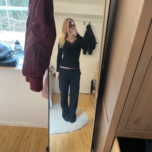 Svart långärmad topp med spetsdetaljer - Säljer en elegant svart långärmad topp med v-ringning och spetsdetaljer runt halsen. Den är från H&M men är nästan aldrig använd. Säljer då jag inte får användning av den. Fråga vid funderingar. 