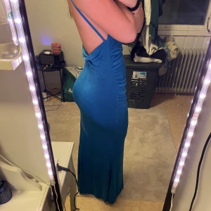 Blå långklänning med öppen rygg - En blå klänning med öppen rygg , jag andvänder den som balklänning, är 166cm och har även klackskor på bilden så den är ganska lång.