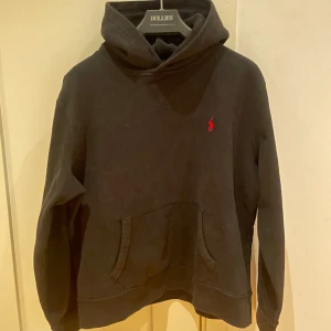 Polo Ralph Lauren Hoodie - Hej! Vi säljer nu denna riktigt schyssta Ralph Lauren hoddien som är perfekt i vardagen. Det är en riktigt snygg passform och denna passar till det mesta! Märke:Polo Ralph Lauren Storlek:M Condition:8,5/10 Färg: Svart med röd logga Tveka inte på att höra av er till oss om ni undrar något angående hoodien. Med vänlig hälsning, SweStile🤝