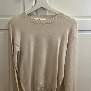 Beige tröja från H&M - Säljer en stilren beige tröja från H&M. Tröjan har en rund halsringning och långa ärmar, perfekt för en avslappnad look. Den är tillverkad i ett mjukt material som känns skönt mot huden. #aldriganvänd #h&m #beige #beigetröja #tröja #långärmad 