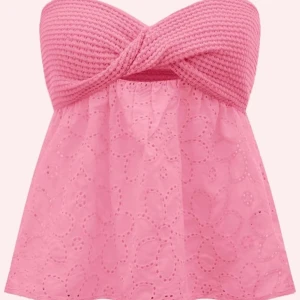 Rosa axelbandslös topp - Säljer en söt rosa axelbandslös topp med en stickad överdel och broderade blommor på den luftiga nederdelen. Toppen har en twistdetalj framtill pris kan sänkas. 