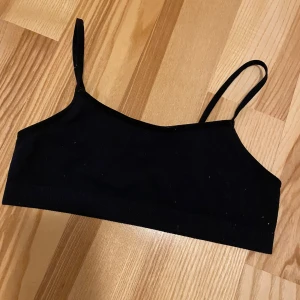 Svart topp - Svart topp med smala justerbara axelband. Lappar bortklippta men dottern har använt den när hon var 10/11 år. 