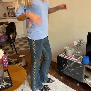 Jeans med snörning - Snygga jeans med unik snörning längs sidorna. De har en klassisk blå färg och en straight passform. Perfekta för att ge din outfit en cool touch.