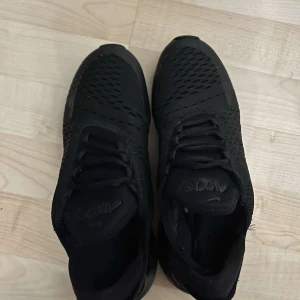 Svarta Nike sneakers - Snygga svarta Nike sneakers med en modern design och bekväm passform. Skorna har en stilren look med snörning och en luftig ovandel. Perfekta för både träning och vardag. Nytt skick och inga defekter 