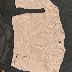 Rosa stickad tröja från Divided - Säljer en söt rosa stickad tröja från Divided. Tröjan har ett diskret mönster och långa ärmar med ribbade muddar. Passar bra till jeans eller kjol. 💖
