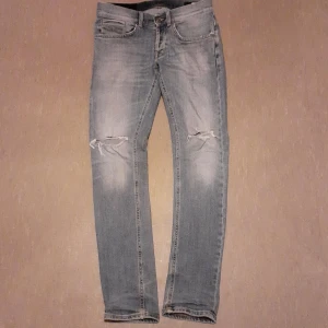 Ljust blå jeans från Dondup - Snygga jeans från Dondup med slitna detaljer på knäna. De har en klassisk femficksdesign och knappgylf. Snygga slitningar på knäna. Modell George.