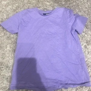 Lila t-shirt från BikBok - Säljer en snygg lila t-shirt från BikBok i storlek XS. Perfekt för en avslappnad stil. T-shirten är kortärmad och gjord i mjukt material.