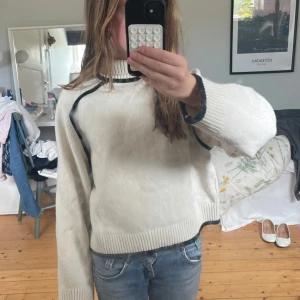 Beige/svart stickad polotröja❣️❣️ - Säljer en beige stickad polotröja med svarta kontrastsömmar och ribbade muddar. Tröjan har en relaxed passform och långa ärmar, perfekt för lager-på-lager. Snygg och enkel att styla till jeans eller kjol. Man måste kontakta innan man köper och som referens är jag 156 cm lång❣️❣️ Priset är DISKUTERBART