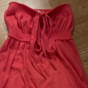 Strapless top  - Jättesnygg strapless top. Rosetten går att knyta upp och knyta runt halsen. Säljer eftersom den blivit för liten.  Kan inte tyda märket på lappen