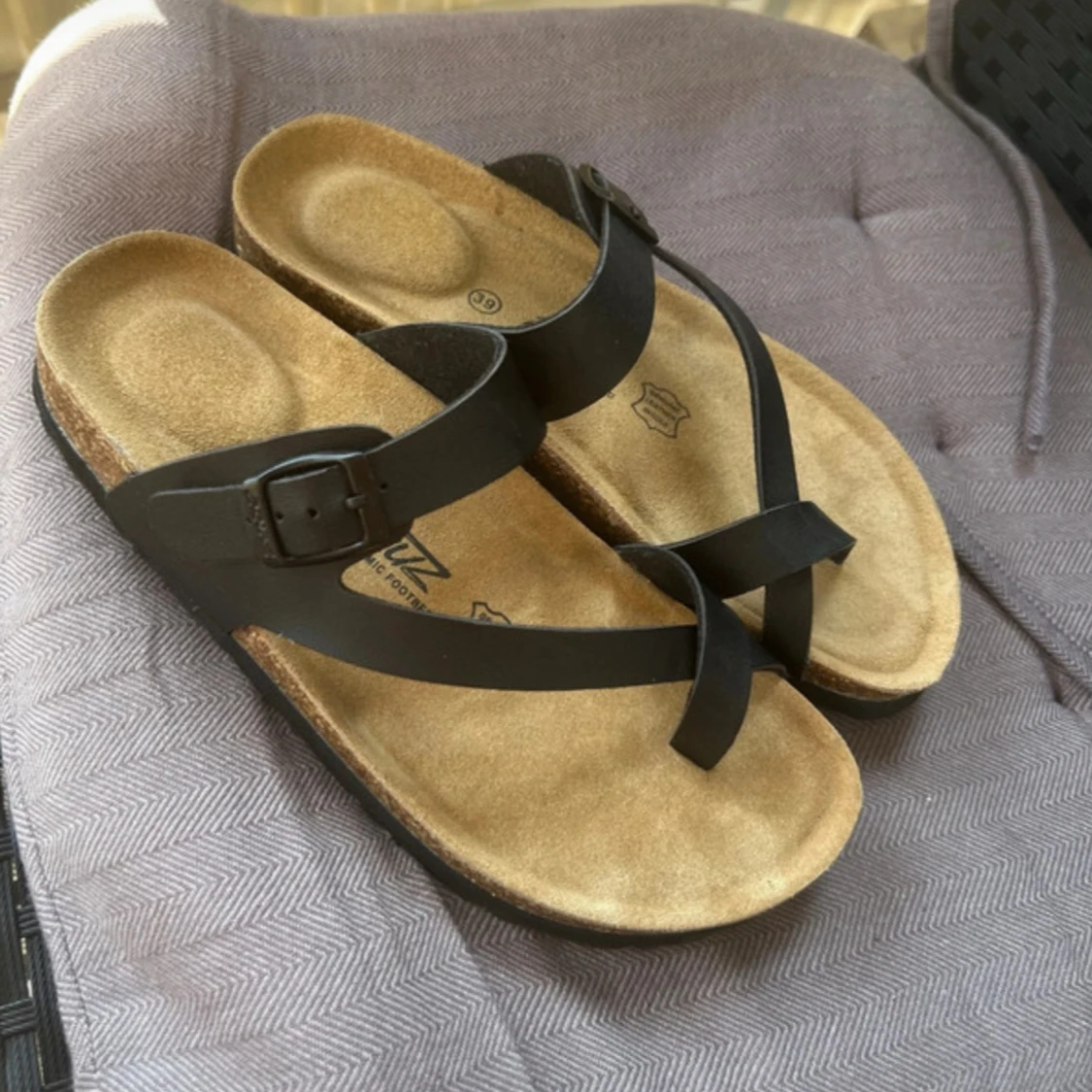 Svarta sandaler i skinn med korsade remmar