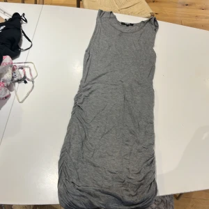 Grå ärmlös klänning från Bik Bok - Enkel och snygg grå ärmlös klänning från Bik Bok i mjuk bomull. Modellen är rak och kort, perfekt för en avslappnad look. Passar dig som gillar basic och stilrent.