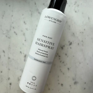 Löwengrip Sensitive Hairspray - Löwengrip Pixie Dust Sensitive Hairspray är en parfymfri hårspray i vit flaska med svart lock. Ger naturlig finish och skyddar stylingen, lätt att borsta ur. Vegansk formula och 250 ml storlek. Helt obruten och oanvänd, fått i gåva. 