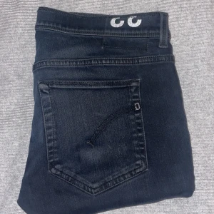 Mörkblå jeans från Dondup, stl 33 - Snygga mörkblå jeans från Dondup, tillverkade i Italien. Klassisk femficksmodell med diskreta sömmar och en stilren look. Jeansen har en normal passform och är gjorda i mjukt denimtyg som sitter skönt hela dagen.