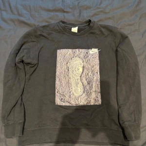 Nike zero gravity sweatshirt - Svart Nike sweatshirt med rund hals Storlek M Alla tryck är i perfekt skick och ser nya ut och allt tecken på slitage kommer från själva sweatshirten.  i bomull med coolt tryck framtill som föreställer ett skoavtryck i sand och texten 'Nike Zero 00.00 Gravity Nineteen-Seventy Two' på ryggen. Trycken på magen är i eget material  Trycket på baksidan är blandat vit och reflekterande grått  Nypris ca 99€ (ca 1000kr) men går ej att få tag i ny längre.    .