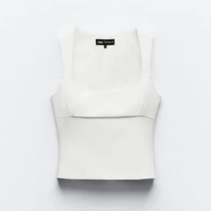 Vit topp Zara - Snygg vit topp från Zara med fyrkantig urringning och breda axelband. Perfekt för att styla med jeans eller kjol. Enkel och stilren design som passar till många olika looks.