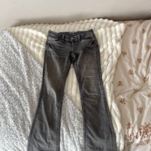 Grå bootcut jeans Gina Tricot 152 - Snygga grå jeans från Gina Tricot i storlek 152. Modellen har bootcut-ben och coola detaljer med kontrastsömmar på bakfickorna. Klassisk femficksdesign och tillverkade i mjukt jeanstyg. Perfekta för dig som gillar en avslappnad men trendig look.