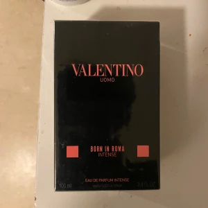 Valentino Uomo Born In Roma Intense 100ml - Exklusiv herrparfym från Valentino, Born In Roma Intense. Kommer i en snygg svart kartong med rosa detaljer och text. Eau de Parfum Intense, 100 ml sprayflaska. Perfekt för dig som vill ha en kraftfull och modern doft.