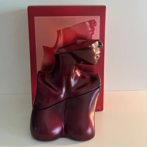 Eilish No. 3 parfym Billie Eilish - Eilish No. 3 Eau de Parfum från Billie Eilish i en unik, mörkröd flaska formad som en byst. Flaskan är tillverkad i metall och glas och har en fin design. Mer än halva kvar av 100 ml. Parfymer var limitiee edition och är svår att få tag på. 