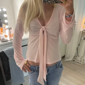 Ljusrosa topp från Gina Tricot med knyt fram - Supersöt ljusrosa topp från Gina Tricot med lång ärm och knyt framtill. Köpt för något år sedan men har bara hängt i garderoben. 💗