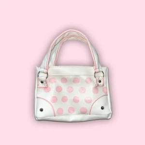 Vit och rosa prickig handväska - Söt handväska i vitt med ljusrosa prickar. Bredd: 25cm höjd: 16cm